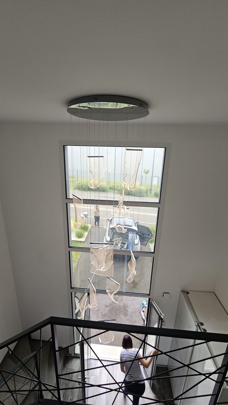 Installation du lustre en cours — cage d'escalier
